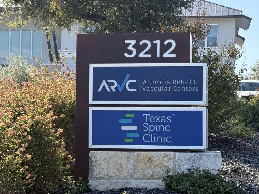 The 3212 monument sign at the street, with the Texas Spine Clinic panel.