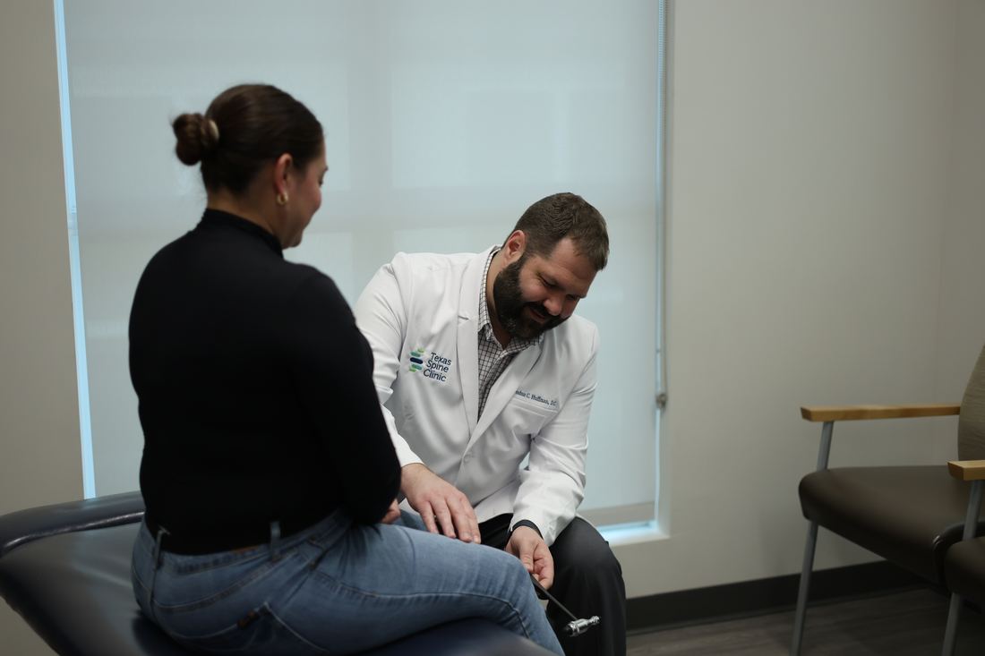 A Texas Spine Clinic doctor in a seated consultation with a patient.