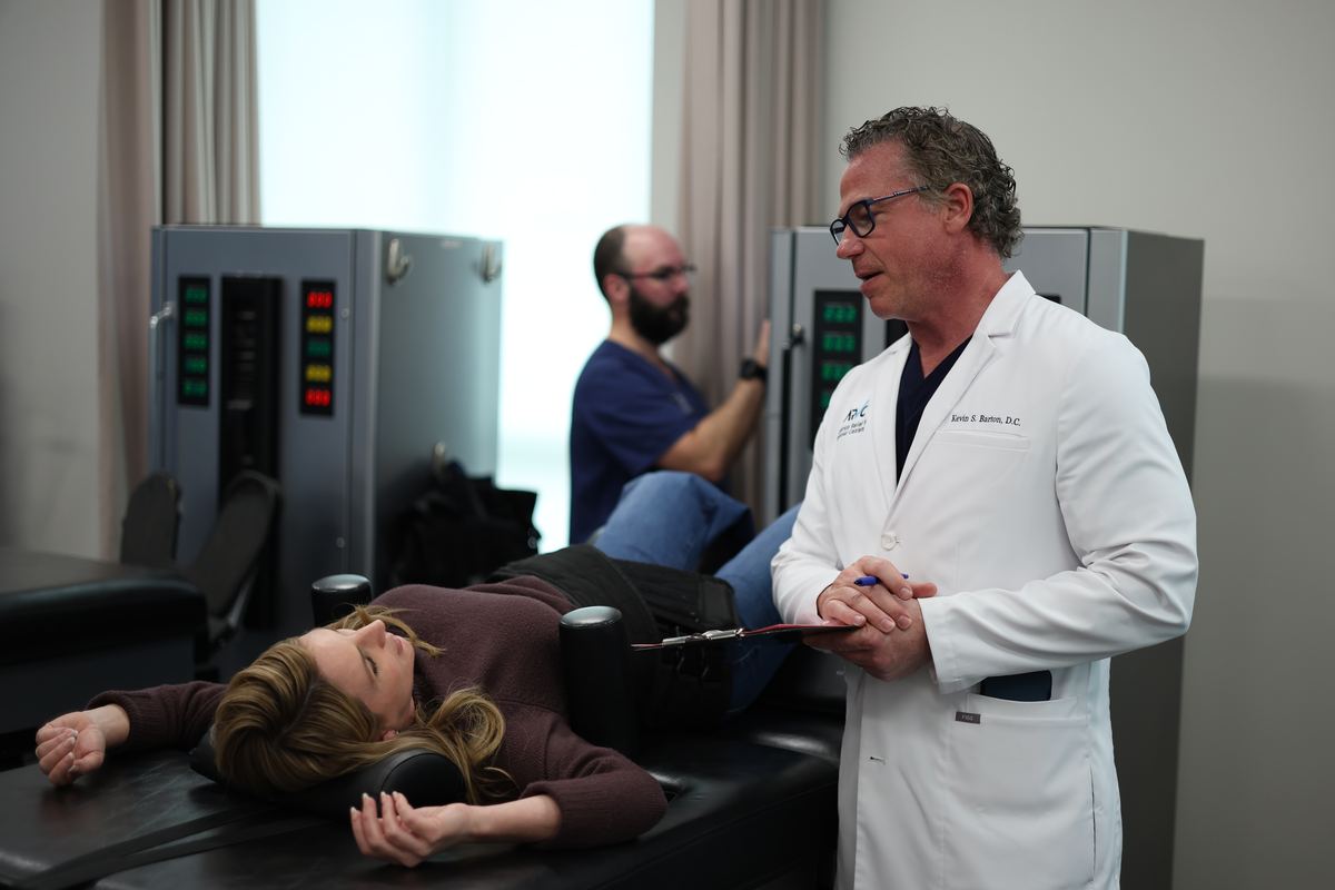 Dr. Kevin S. Barton, D.C., standing beside the DRX9000 at Texas Spine Clinic.