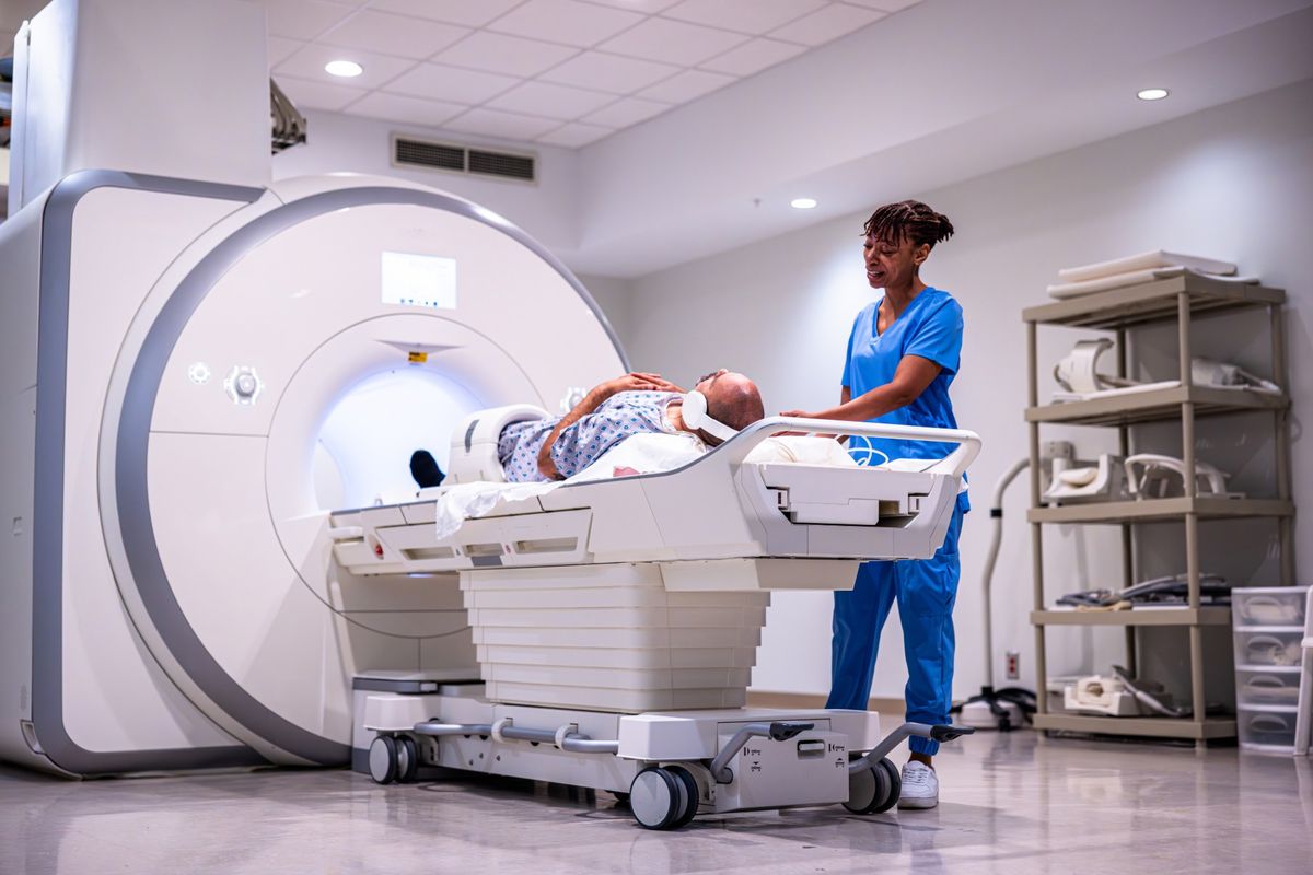 A technologist getting a patient settled on the table for an MRI scan.