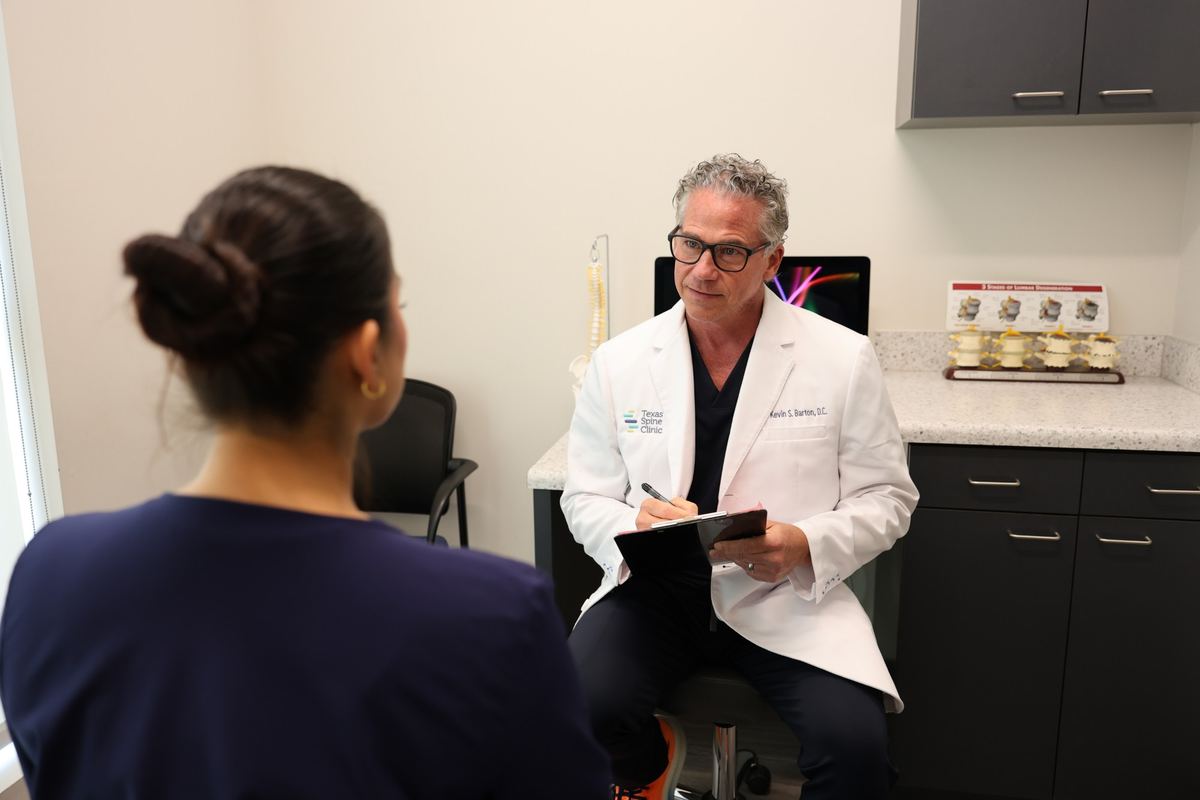 Kevin S. Barton, D.C., taking notes during a patient consultation.