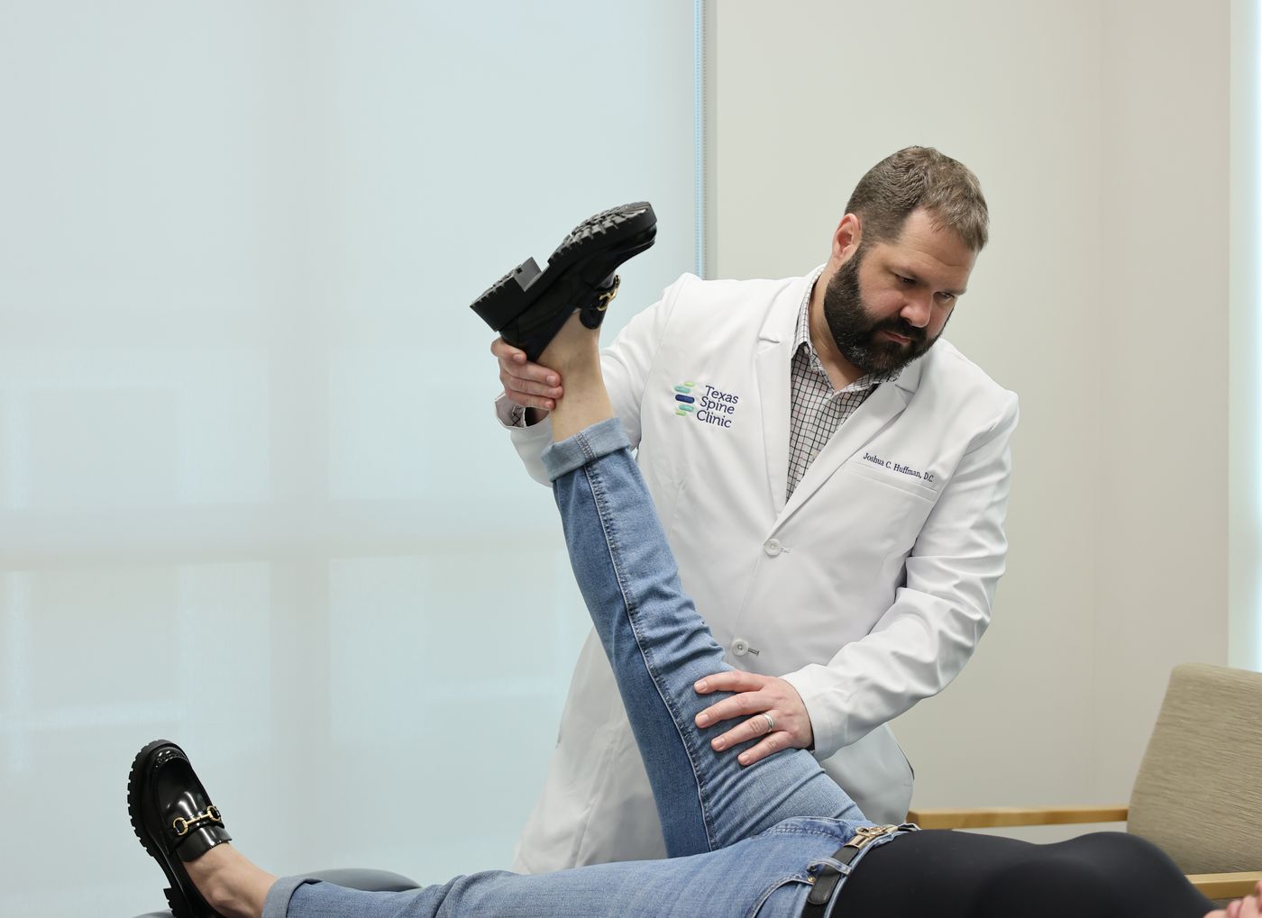 Dr. Joshua C. Huffman performing a straight-leg-raise test during a lower back examination.