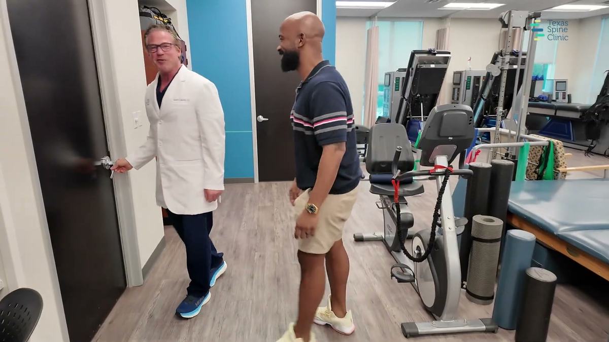 Dr. Barton and a patient walking through the clinic's therapy area after a scrambler therapy session, both smiling.