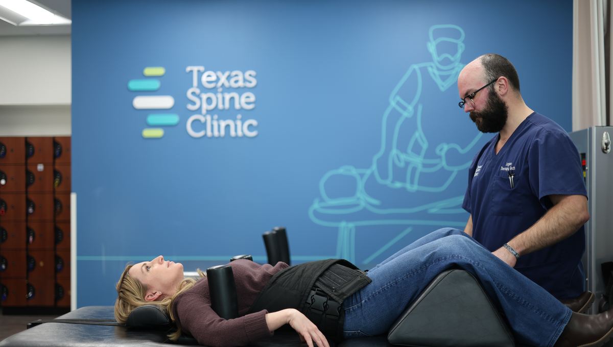 A patient lying fully clothed on the DRX9000, harnessed at the hips, during a decompression session.