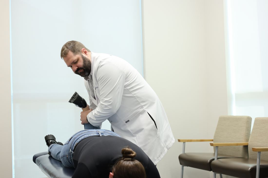 Yeoman's test being performed on a patient lying face down during a spinal examination.