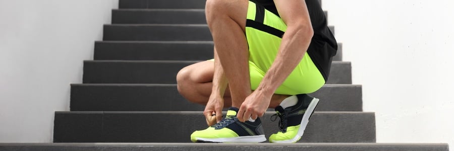 An athlete ties his shoes