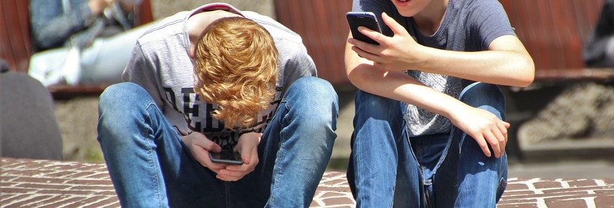 Two teenagers on their phones